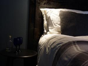 纽基Skyline Guesthouse的一间卧室配有一张床和一张带葡萄酒杯的桌子