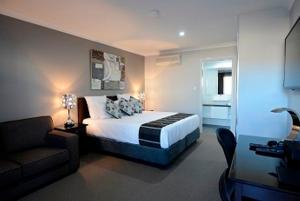 帕克斯天文菜汽车旅馆 的一间卧室配有一张床和一个沙发