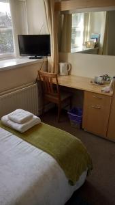 柯库布里斯达尔酒店的一间卧室配有书桌和一张带椅子的床