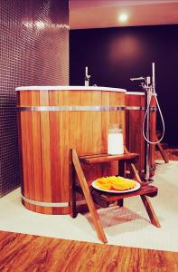 奥格罗杰涅茨Poziom 511 Jura Wellness Hotel & Spa的浴室设有木浴缸,桌子上有一个盘子