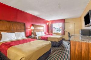 夏洛特Econo Lodge Charlotte Airport Area的酒店客房设有两张床和一台平面电视。