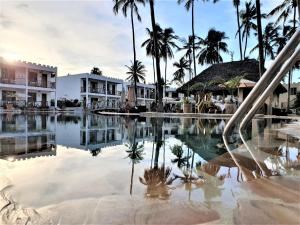 乌罗阿Zanzibar Bay Resort & Spa的棕榈树度假村的游泳池