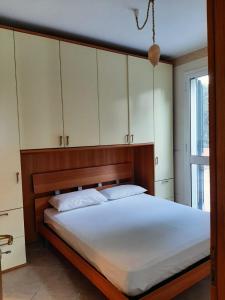 圣凯撒利亚温泉Villetta a pochi passi dal mare的一间卧室配有一张带白色橱柜的大床