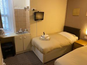 布莱克浦Grange House Hotel的一间小卧室,配有两张床和盥洗盆