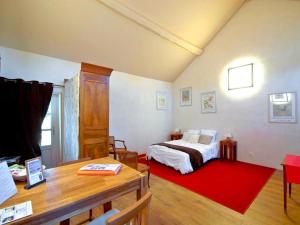 PréhyLes Temps Perdus的一间卧室配有一张床和红色地毯
