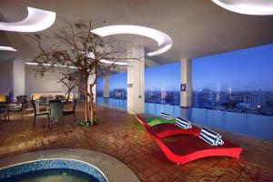 马卡萨ASTON Makassar Hotel & Convention Center的建筑中带游泳池和树的房间