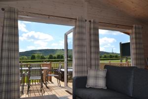 ChinnorThe Chiltern Lodges at Upper Farm Henton的客厅配有沙发和带屏风的门廊。