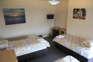 利物浦Clifton arms的酒店客房配有两张床和一张书桌