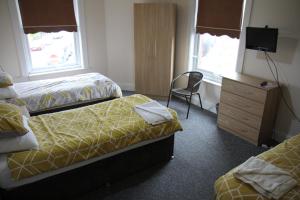利物浦Clifton arms的酒店客房,配有两张床和椅子