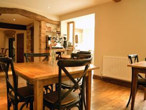 切尔滕纳姆The Plough Inn的一间带木桌和椅子的用餐室