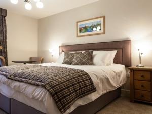 纽敦Parkers House Bed & Breakfast的一间卧室配有一张大床和木制床头板