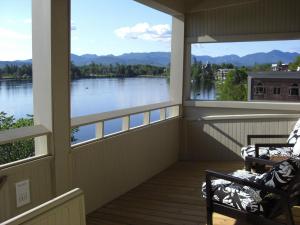 普莱西德湖镜湖公寓式酒店的一个带两把椅子的屏风门廊,享有湖景