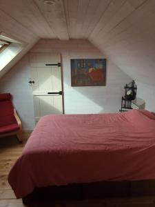赫拉尔兹贝亨Vakantiewoning De Wilg - rustig gelegen的阁楼卧室配有红色床
