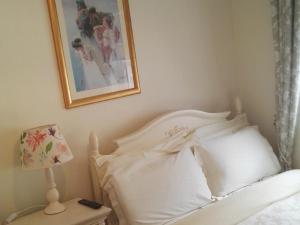 沃特福德The Vee Guest Accommodation的卧室配有白色的床,墙上挂着一幅画