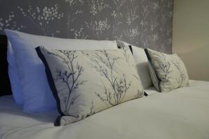 马勒姆The Victoria的一张带白色枕头和花卉壁纸的床