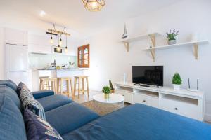 阿雷西费Vela的一间带蓝色沙发的客厅和一间厨房