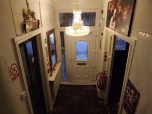布莱克浦Thistle Dhu Guest House的走廊上设有白色门和吊灯