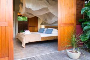 勒穆莱香巴拉山林小屋的门廊上的一张带蓝色枕头的床