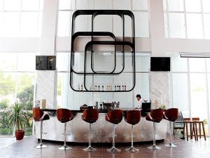 雅加达雅加达布鲁特 - 哈尼瑞斯通套房酒店的厨房设有带红色吧台凳的酒吧