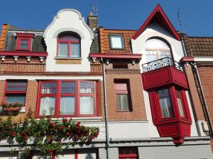 Hellemmes-Lille奥特劳巴朵酒店的红色的白色建筑,设有红色的窗户