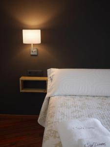 ArenHotel Domenc的卧室配有一张带墙上灯的床。