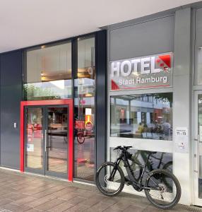 萨尔布吕肯Hotel Stadt Hamburg am Fluss Saarbrücken的停在酒店商店前面的自行车