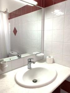 帕罗奇亚Rodia Studios & Apartments的白色的浴室设有水槽和镜子