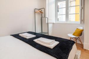 里斯本Gonzalo's Guest Apartments - Downtown Historic Flats的白色客房,配有带毛巾的床