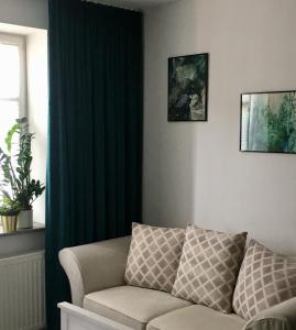 奥尔什丁kameralny apartament II的客厅的沙发,配有绿色窗帘
