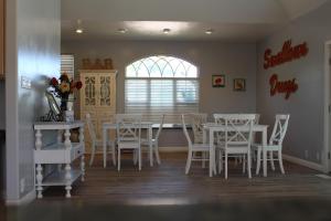 PanacaSwallow Cove的一间设有白色桌椅和窗户的用餐室