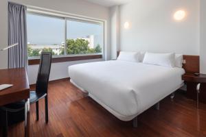 费尔盖拉什B&B HOTEL e Apartamentos Felgueiras的窗户客房内的一张大白色床