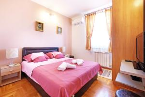 贝尔格莱德Villa Tower Gardos的一间卧室配有粉红色的床和2条毛巾