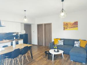 卡兰巴卡Meteora Rocks Apartment 1的客厅以及带蓝色沙发和桌子的厨房。
