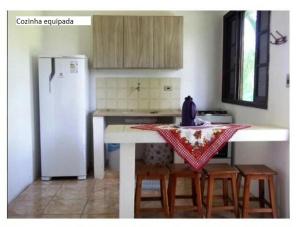 伊利亚孔普里达Samburá Chalés的厨房配有桌椅和冰箱。