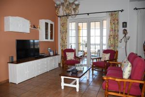 特尔德Pedro's house with fantastic views的客厅配有平面电视和红色椅子。
