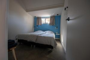 内斯BeachWay的一间卧室配有一张蓝色墙壁的床