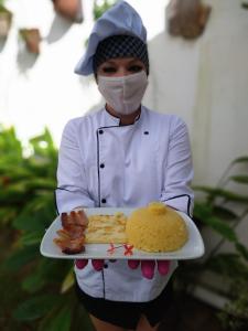 纳塔尔美利加多索旅馆的戴着面具,拿着一盘食物的人