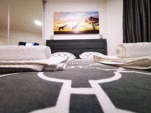 尼什Merkur Luxury Apartman的一间卧室配有两张床,并画有长颈鹿的照片