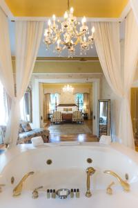 萨凡纳The Gastonian, Historic Inns of Savannah Collection的带浴缸的大浴室和客厅。