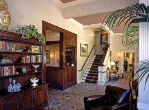 圣罗莎玫瑰酒店的一间带楼梯和书架的客厅