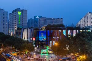南京南京水游城假日酒店的繁忙的城市街道,晚上有建筑