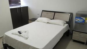 La Jagua de IbiricoHotel Jagua Real的卧室配有白色大床和橱柜