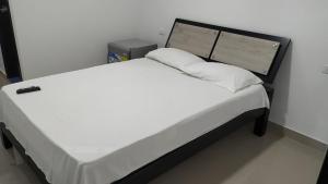 La Jagua de IbiricoHotel Jagua Real的一张配有白色床单和枕头的大床
