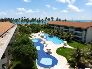 普拉亚多斯卡内罗斯Carneiros Beach Resort - Paraíso Beira Mar的享有带游泳池的度假村的空中景致