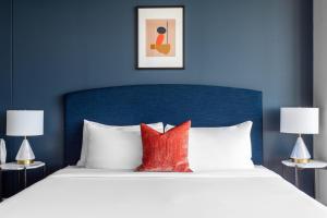 达拉斯Mint House Dallas - Downtown的一张带蓝色床头板和红色枕头的床