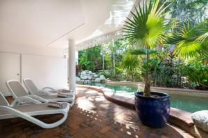 道格拉斯港白宫道格拉斯港公寓酒店的一个带椅子的游泳池,一个棕榈树