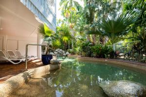 道格拉斯港白宫道格拉斯港公寓酒店的一座树木繁茂的建筑中间的游泳池