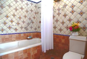 瓜达拉哈拉金塔唐何塞精品酒店的带浴缸和花瓶卫生间的浴室