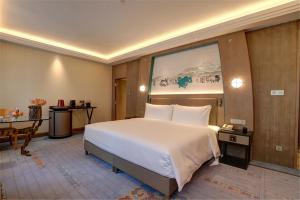 成都成都西藏饭店（尊享欢迎藏茶礼遇）的酒店客房设有一张大床和一张桌子。