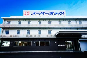 富士宫市Super Hotel Fujinomiya的白色的建筑,上面有标志